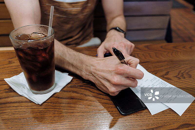男人在餐厅签署信用卡收据图片素材