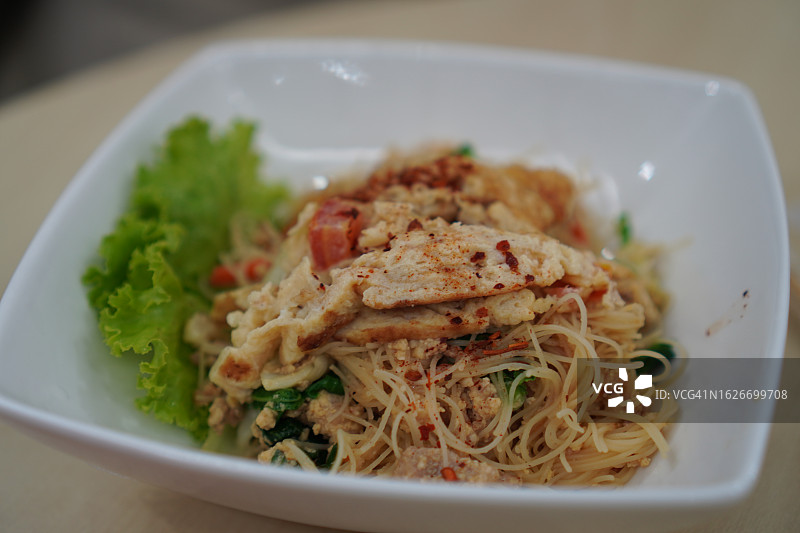 胡萝卜炒鸡肉面和桌上的红色冰水图片素材