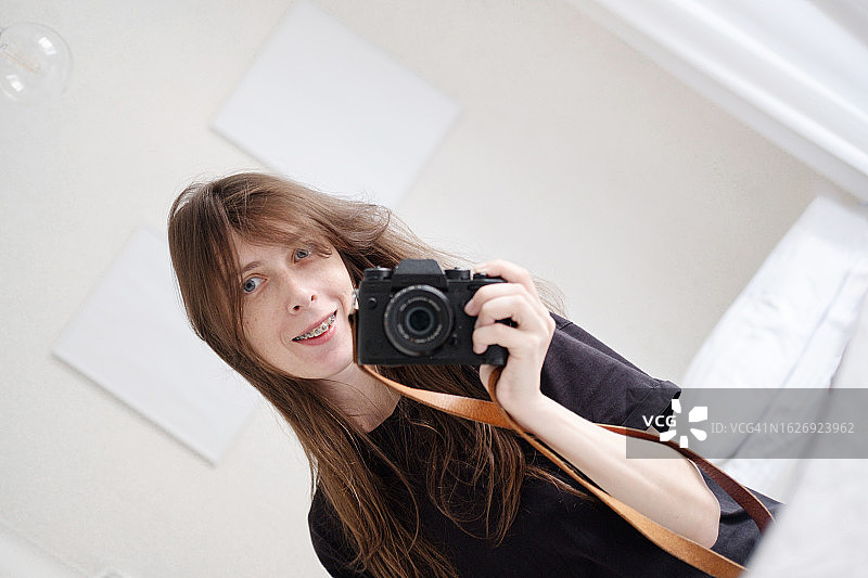 可爱的棕发女孩在镜子前自拍图片素材