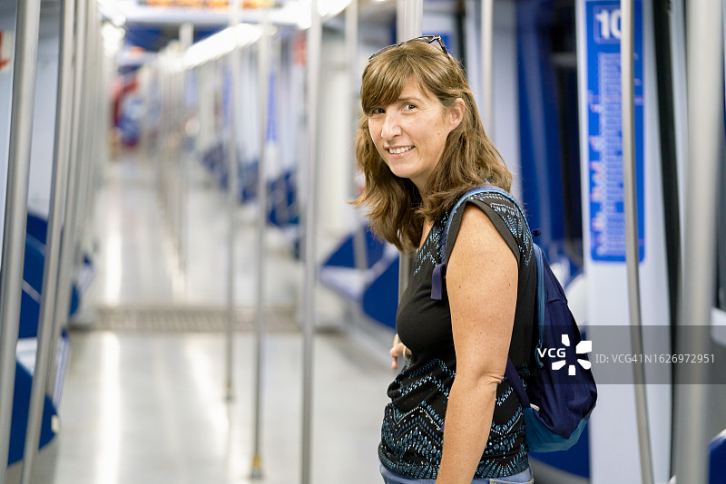 地铁里的休闲装微笑女子图片素材