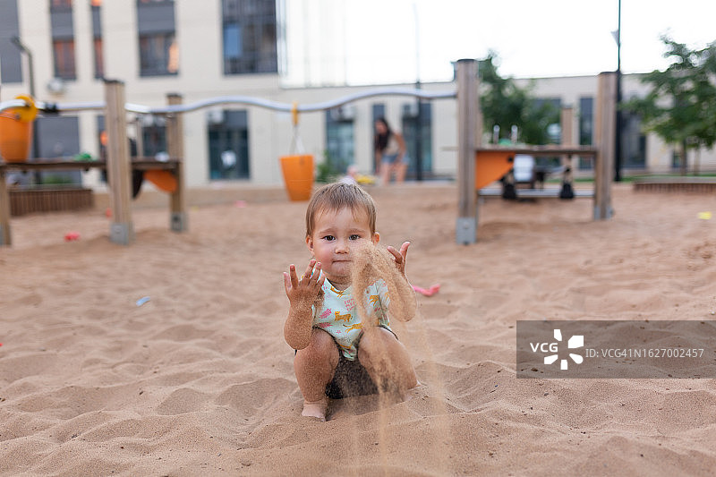 夏天，小女孩在操场上玩沙子图片素材
