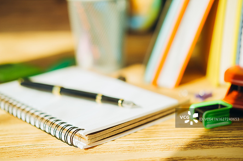 木桌上的钢笔、文具和书籍图片素材
