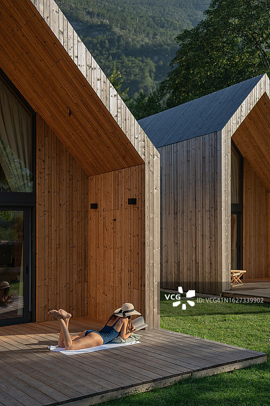 年轻女人在小屋门廊上放松图片素材