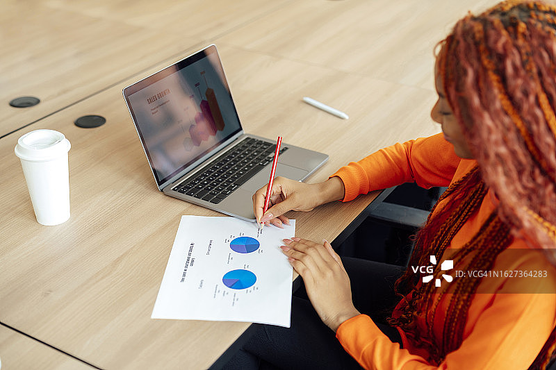 女商务人士在办公室用笔记本电脑准备报告图片素材