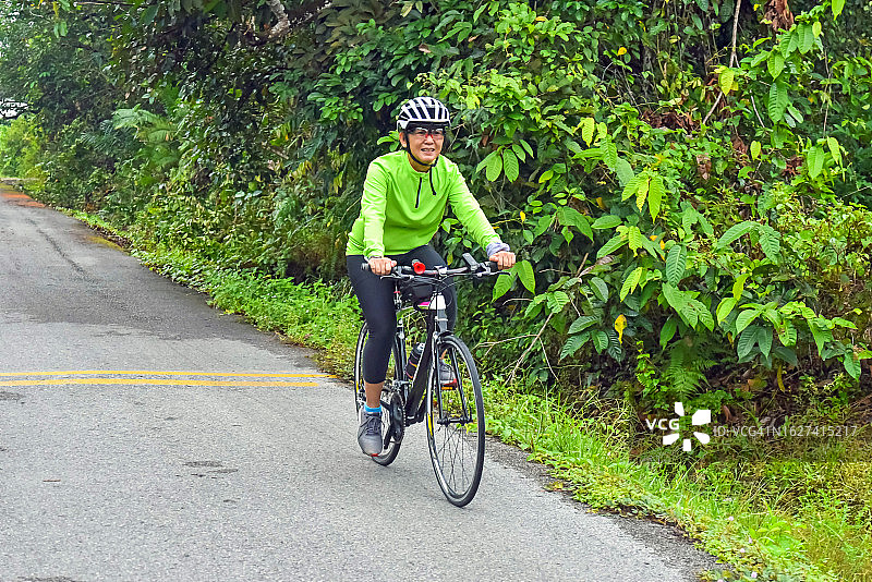在乡下骑自行车的亚洲女人图片素材
