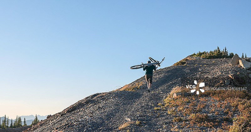 山地自行车手扛车上坡图片素材