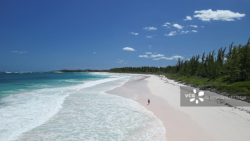 航拍：女子在空旷的海滩上探索图片素材
