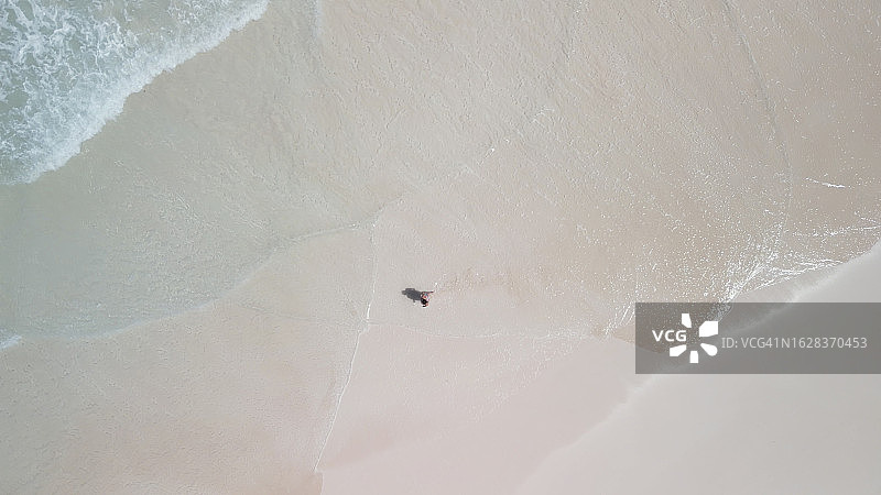 躺在空旷海滩上的女人鸟瞰图图片素材