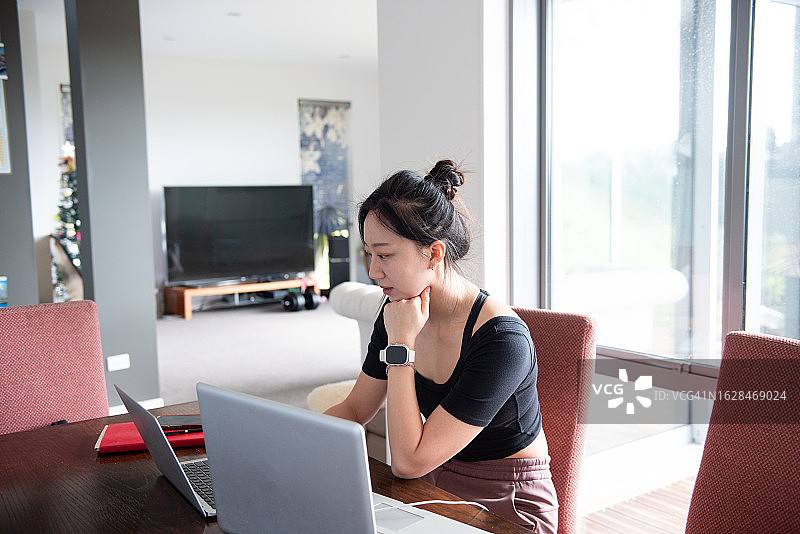 一位年轻的亚洲女子在家工作图片素材
