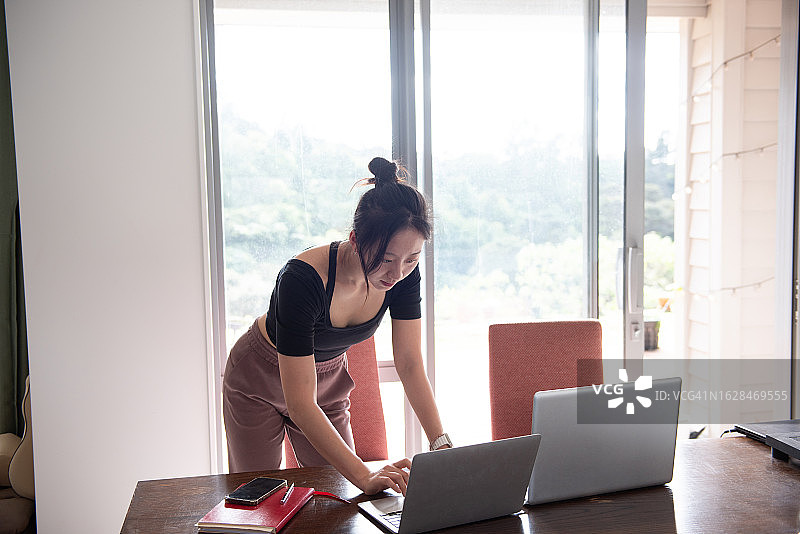 一位年轻的亚洲女子在家工作图片素材