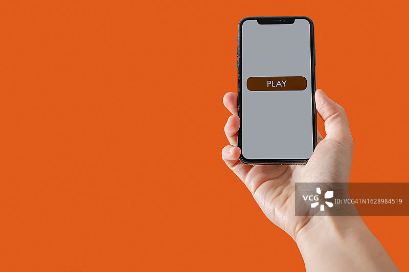 拿着智能手机，屏幕上有播放按钮的手图片素材