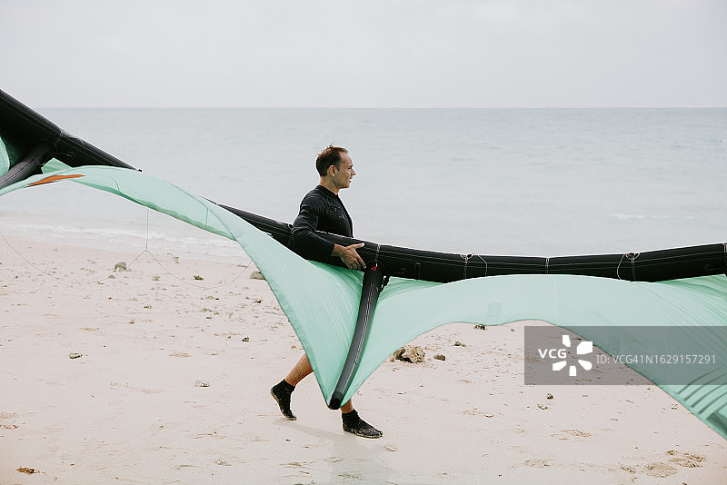 风筝冲浪者扛风筝走向大海图片素材