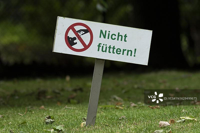 象征性图像，特写，带有禁止喂食标志的绿色草地，德国图片素材