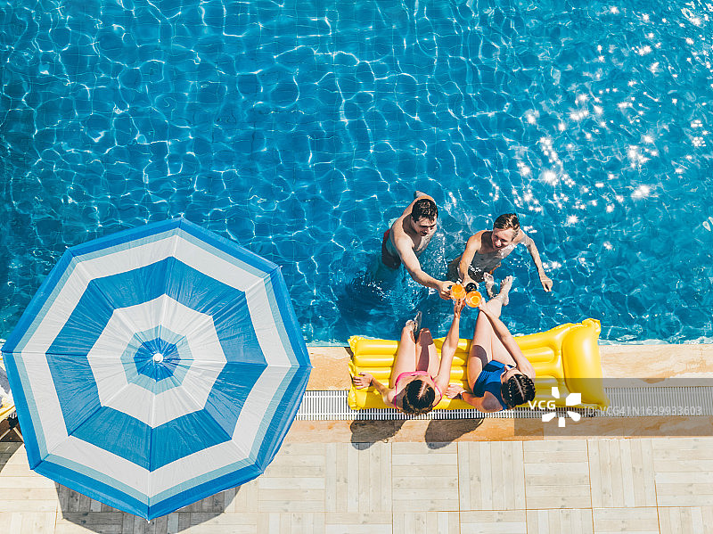 一群多元化朋友喝酒，一起举办泳池派对图片素材