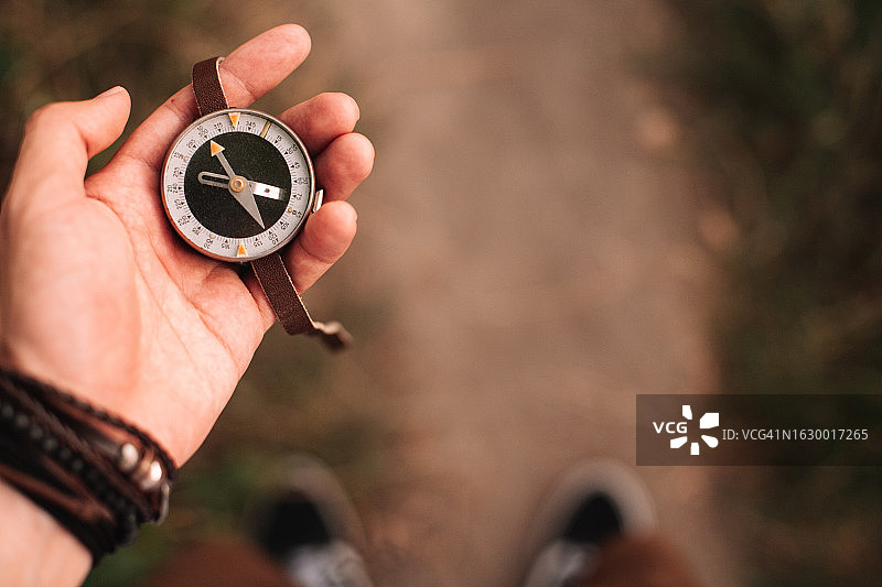 旅行者在森林小路上手持导航罗盘图片素材