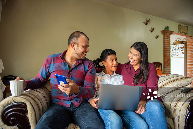 父母和儿子一起看笔记本电脑图片素材