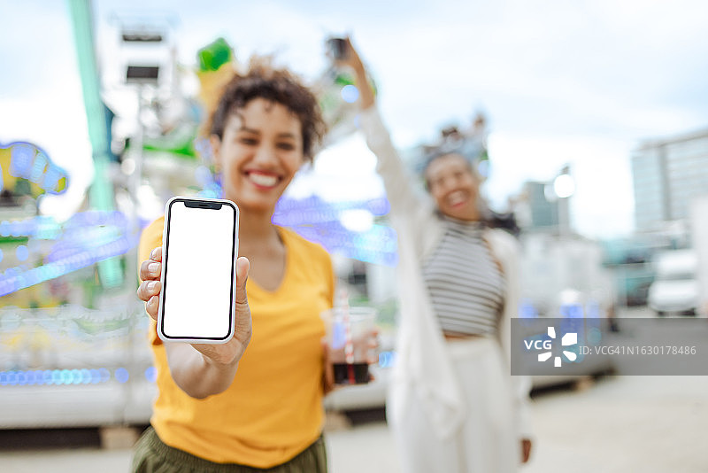 年轻女人手持白色屏幕的手机图片素材