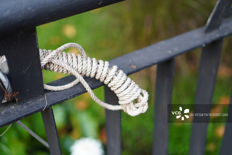 缠绕在黑色铁柱上的绳索图片素材