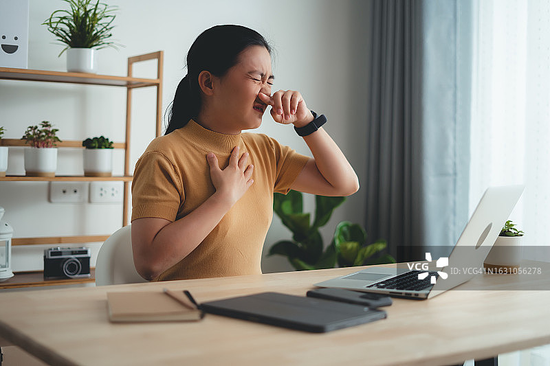 亚洲女人发烧喉咙痛，在家办公图片素材