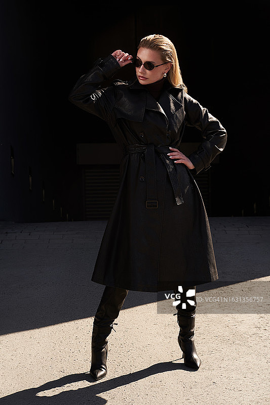 城市里的年轻漂亮女人，穿着黑色皮夹克和太阳镜，都市生活图片素材