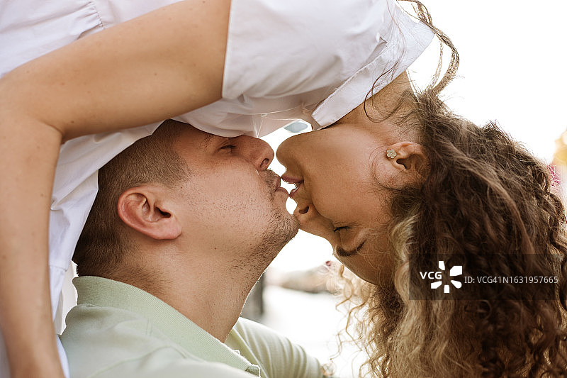 女人弯腰亲吻男人的侧面图片素材