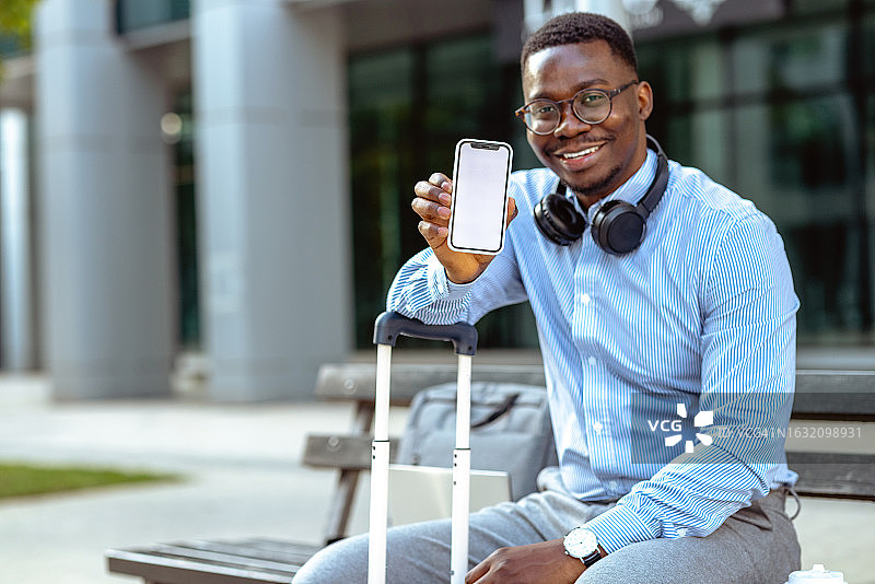 展示手机屏幕的非裔美国青年图片素材