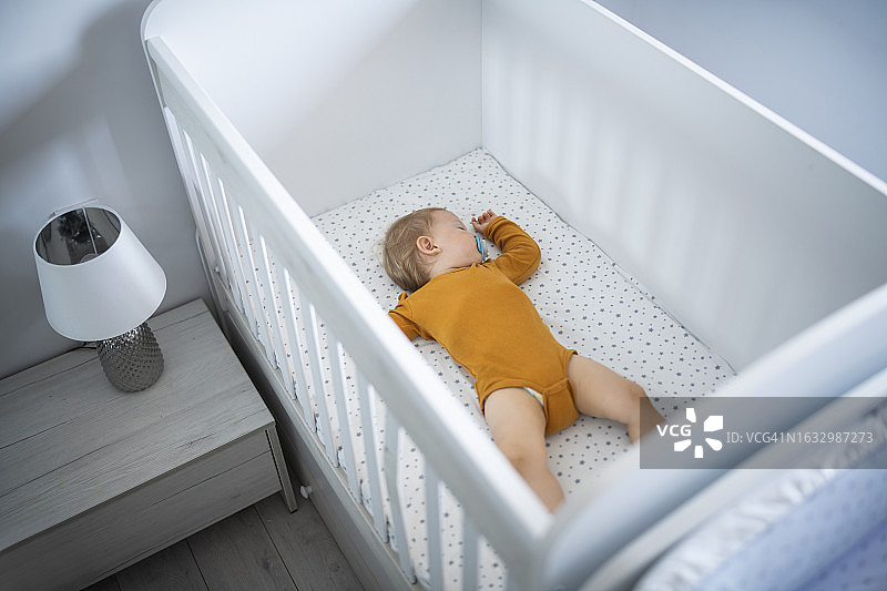 男婴在婴儿床上安静地睡觉图片素材