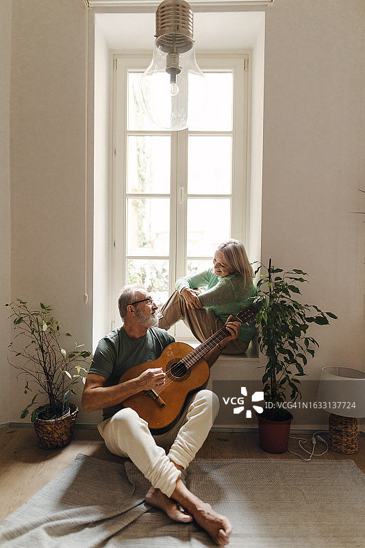 年长的男人为妻子弹奏浪漫的吉他曲图片素材