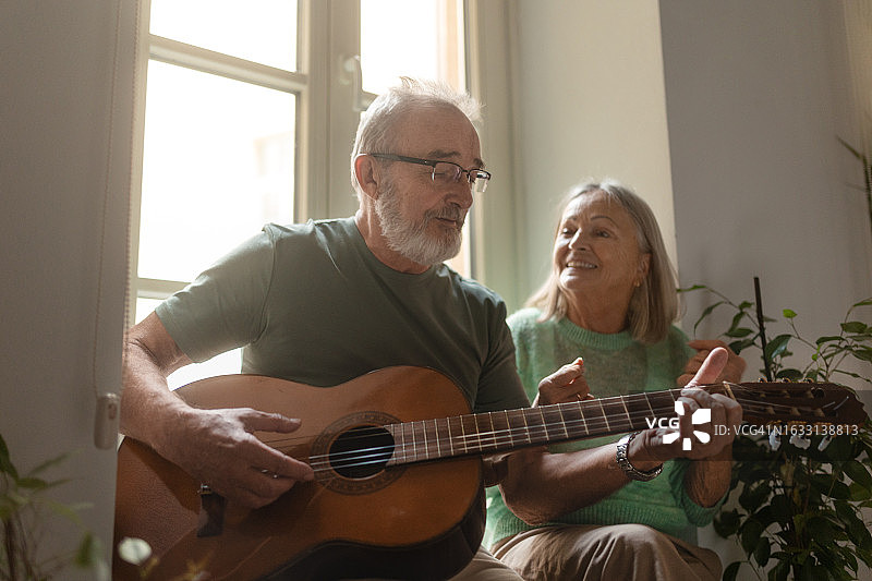 年长的男人为妻子弹奏浪漫的吉他曲图片素材