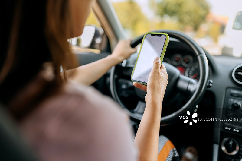 特写镜头：女人开车时发短信图片素材