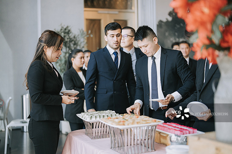 参加商务会议的中国籍亚洲人在茶歇时喝咖啡图片素材