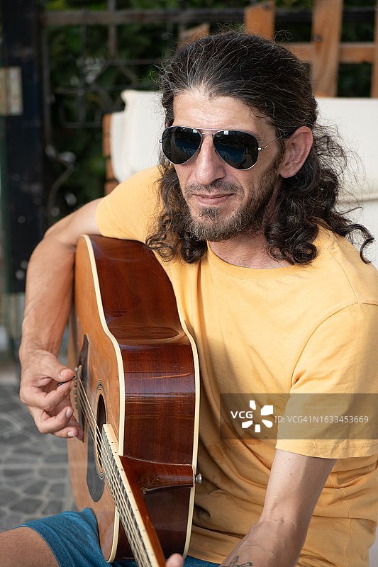 年轻音乐家在泳池里弹吉他图片素材