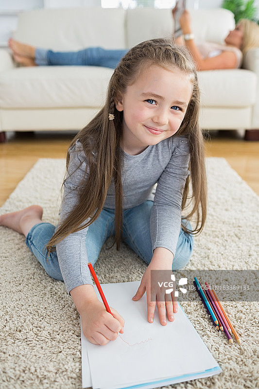 快乐的女孩和妈妈一起画画看报纸图片素材