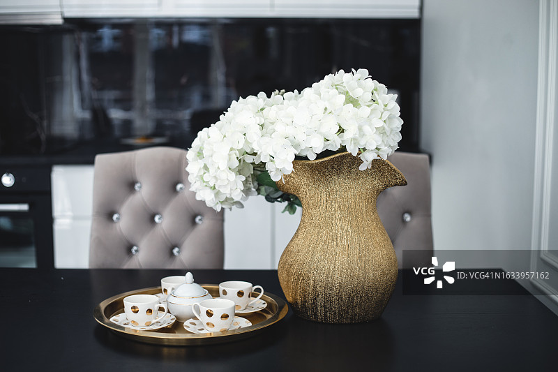 现代风格的深浅色调厨房照片，配有桌子和鲜花图片素材