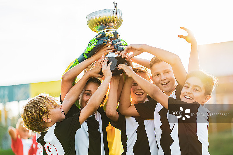 年轻的足球运动员庆祝足球杯图片素材