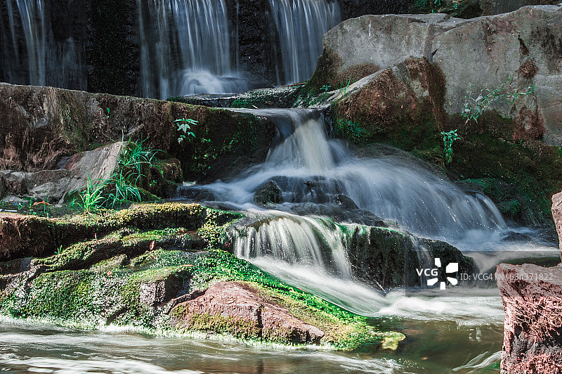 绿苔石头上的湍急溪流图片素材