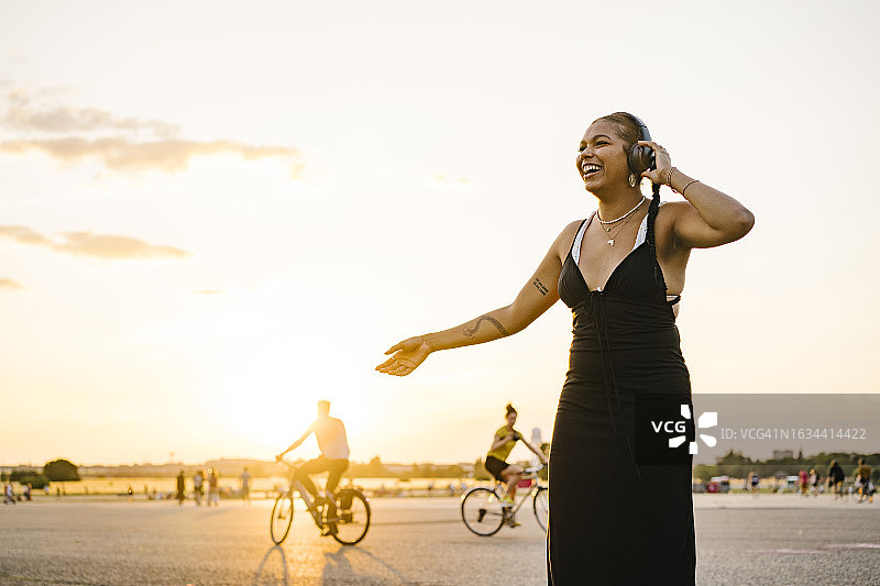 年轻女子在公园里听音乐跳舞图片素材