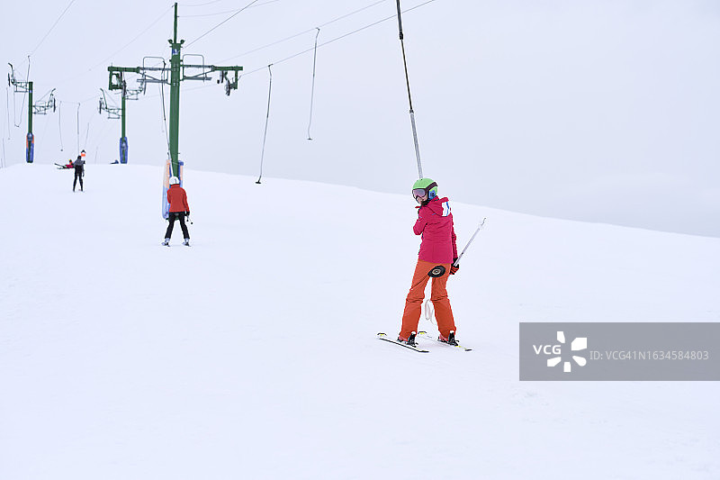 使用安全防护设备滑雪的少女背影图片素材