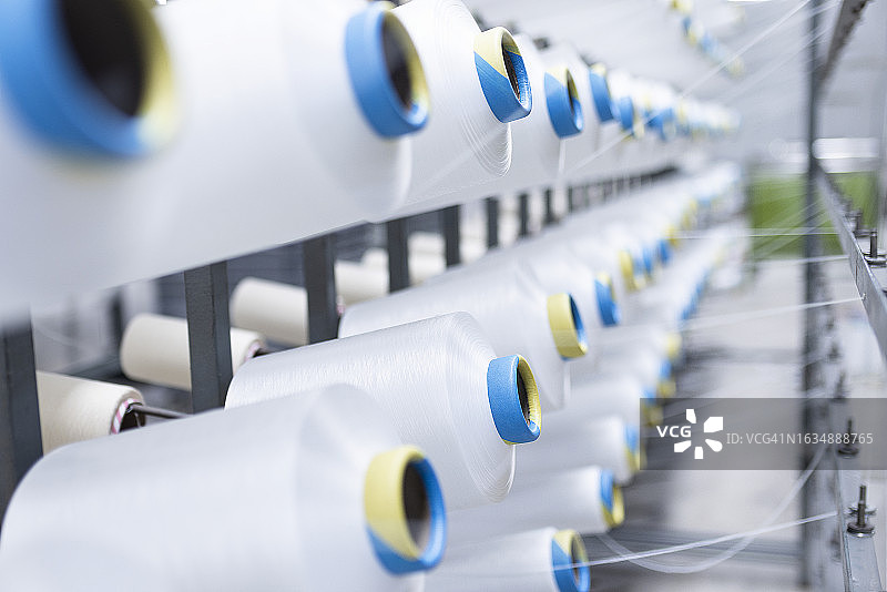 纺织厂工业整经机上的白色纱线轴图片素材