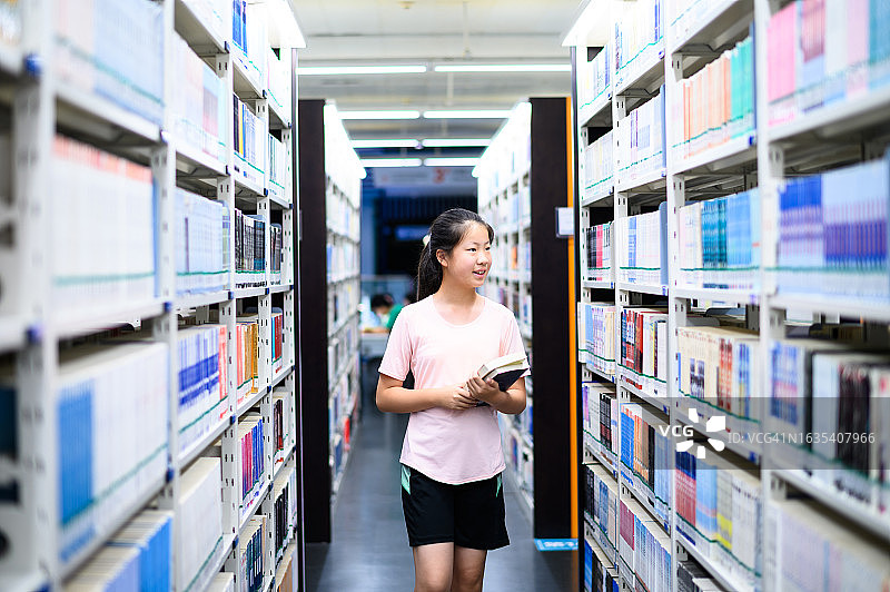 亚洲初中学生在公共图书馆借阅书籍图片素材