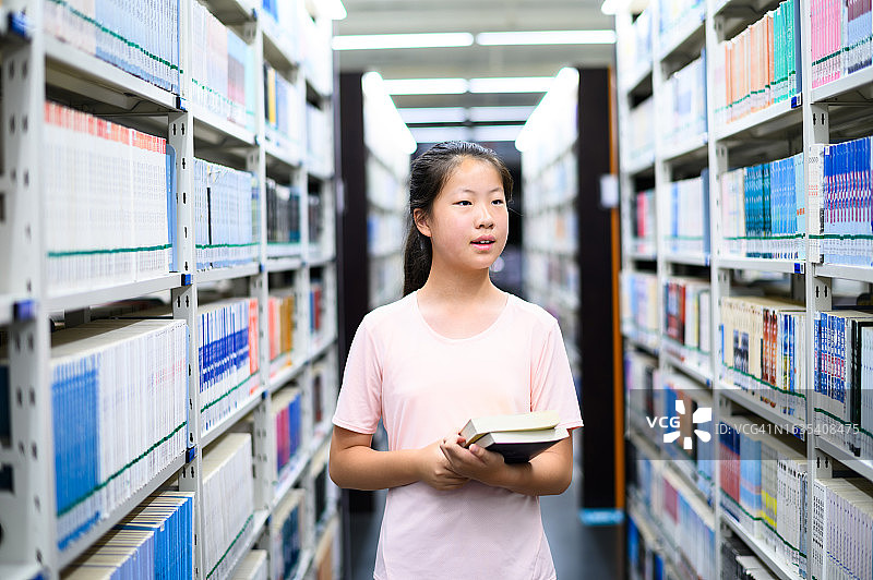 亚洲初中学生在公共图书馆借阅书籍图片素材