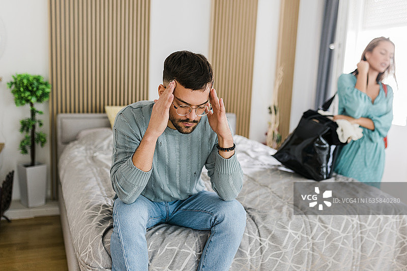 年轻夫妇关系不和，争吵后女人收拾行李离开图片素材