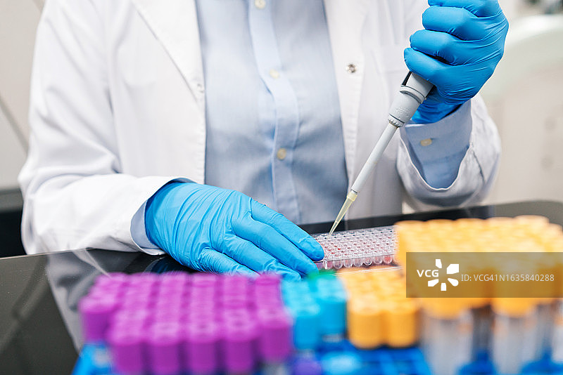 女医务人员在实验室用移液管填充化学物质图片素材