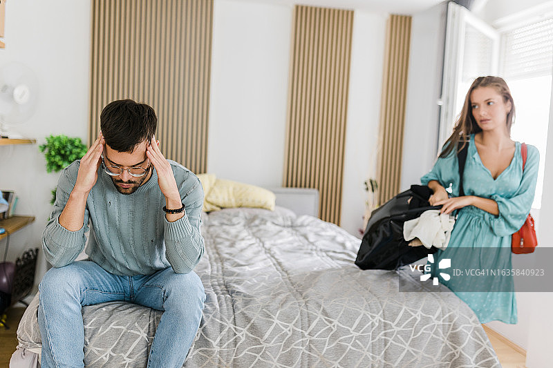 年轻夫妇关系不和，争吵后女人收拾行李离开图片素材