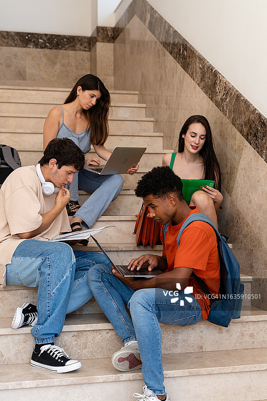 学生们在楼梯上用笔记本电脑一起学习图片素材