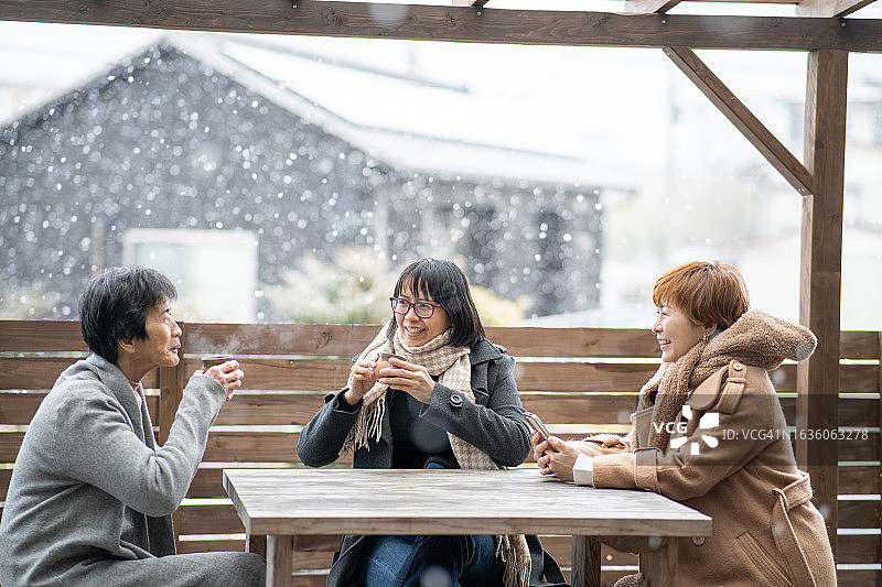 中国家庭在后院享受雪中热饮图片素材