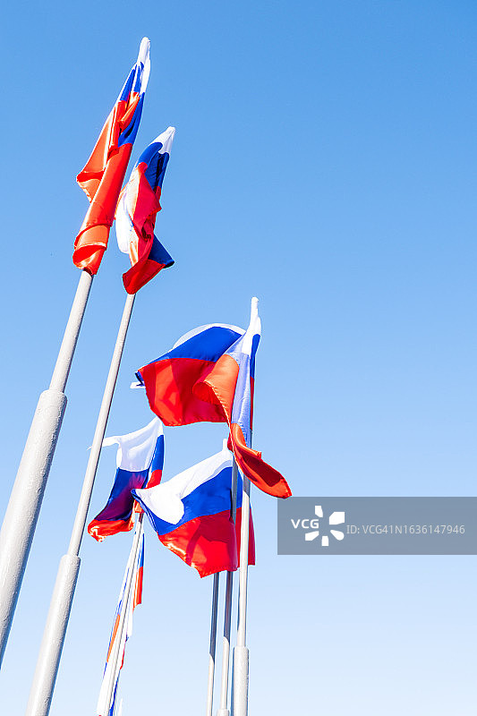 蓝色天空背景下的俄罗斯国旗图片素材