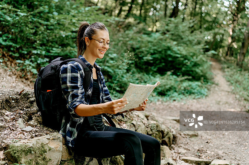 女人使用地图引导她的徒步探险图片素材