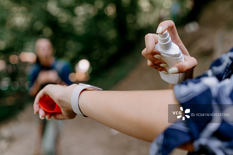 年轻女人在户外使用驱蚊喷雾图片素材