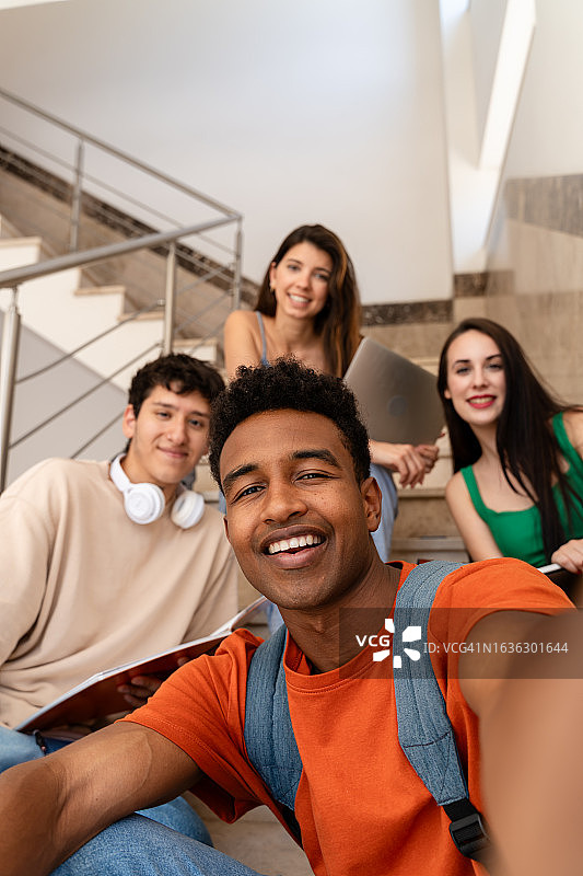 一群学生在课间休息时在楼梯上自拍并微笑图片素材